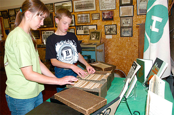 Polk County 4-H'ers Michaela Higginbotham and Jacob Toombs look over some of the 4-H memorabilia they helped collect for a display in the Polk County Museum in Bolivar, MO.